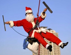 Мойщик окон, переодетый в костюм Санта-Клауса на одном из небоск