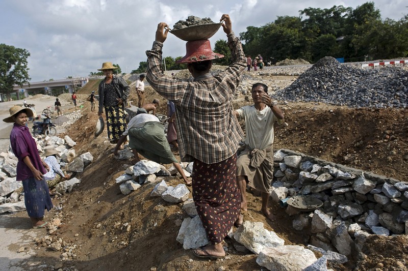 Рабочие строят дорогу в Sagaing на окраине города Мандалай