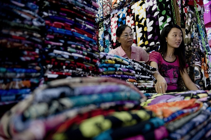 Китаяно-бирманка, слева, и ее дочь, в их собственном магазине ткани на китайском рынке