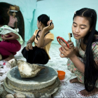 Девочки накладывают пудру танака внутри здания пагоды Kaung Му Тау
