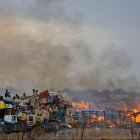 Грузовик с ворованными вещами на фоне горящих хижин в центре города Абайи, Судан. Десятки тысяч суданцев бегут из неспокойного с