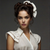 Image is a high-fashion portrait featuring a woman with voluminous, curly brown hair styled dramatically